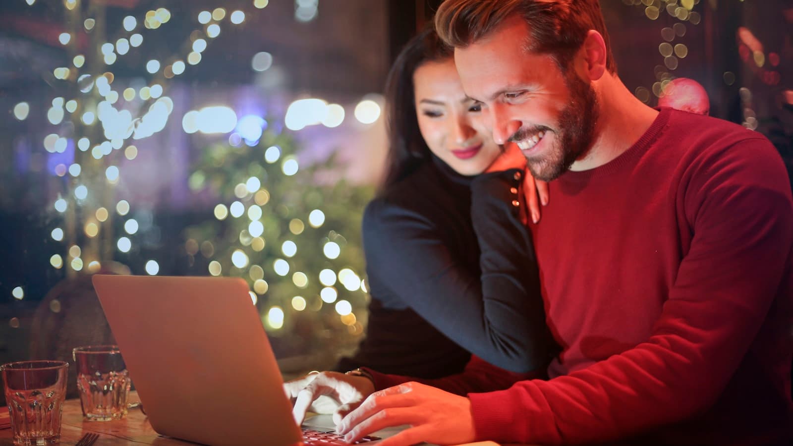 Engaged couple sitting at a kitchen table planning their wedding together